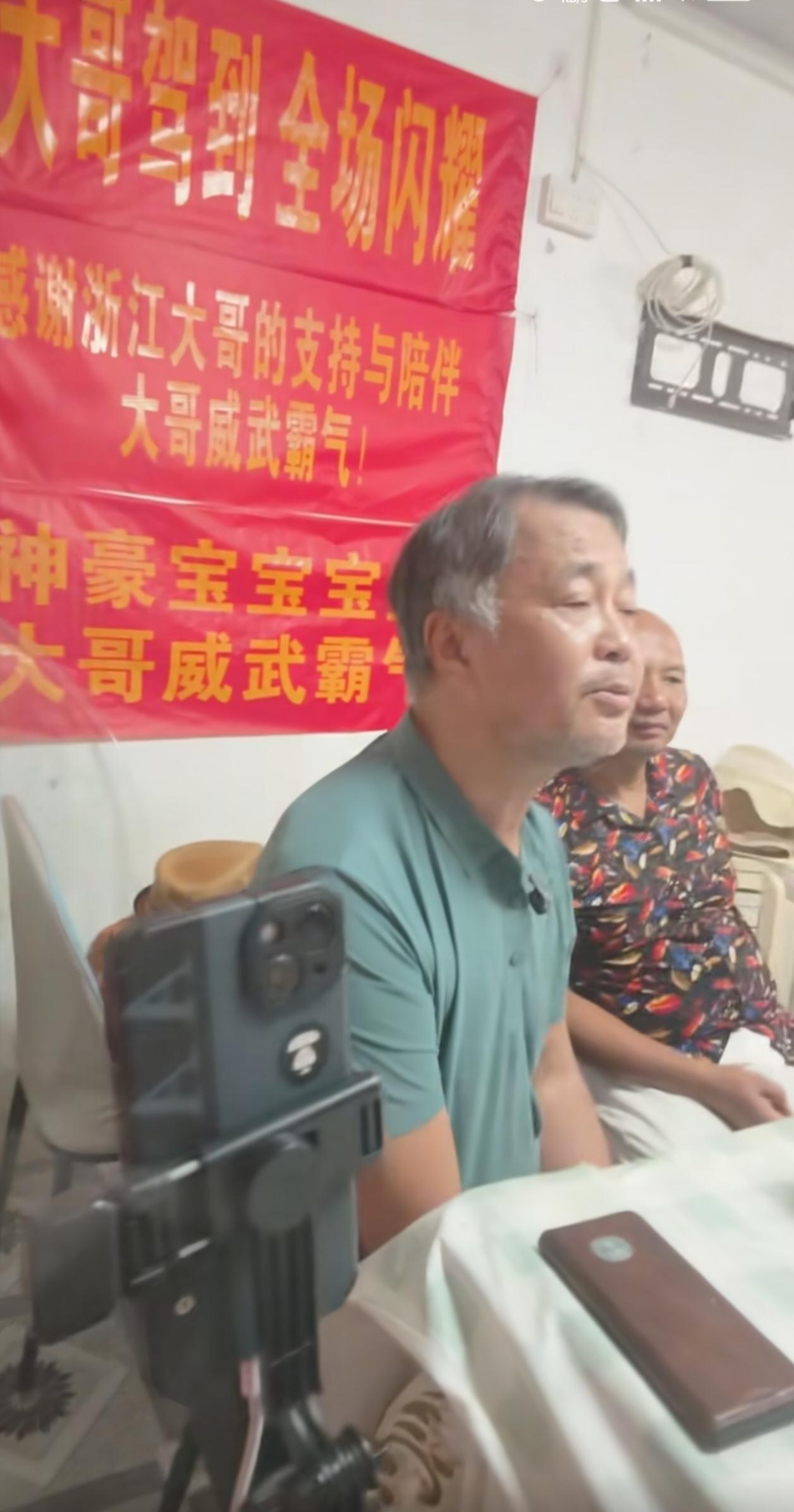沈巍现身光二基地开启直播，再度唱起他的那首“成名曲”《为你打开一扇窗》，墙面悬挂