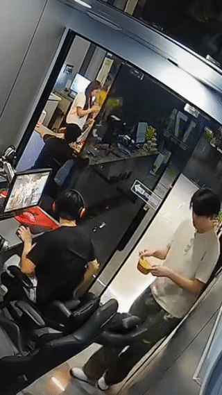 一名男孩突然失手将一碗热汤面浇在了旁边正在玩游戏的黑衣男孩脖子上？
不过仔细看了