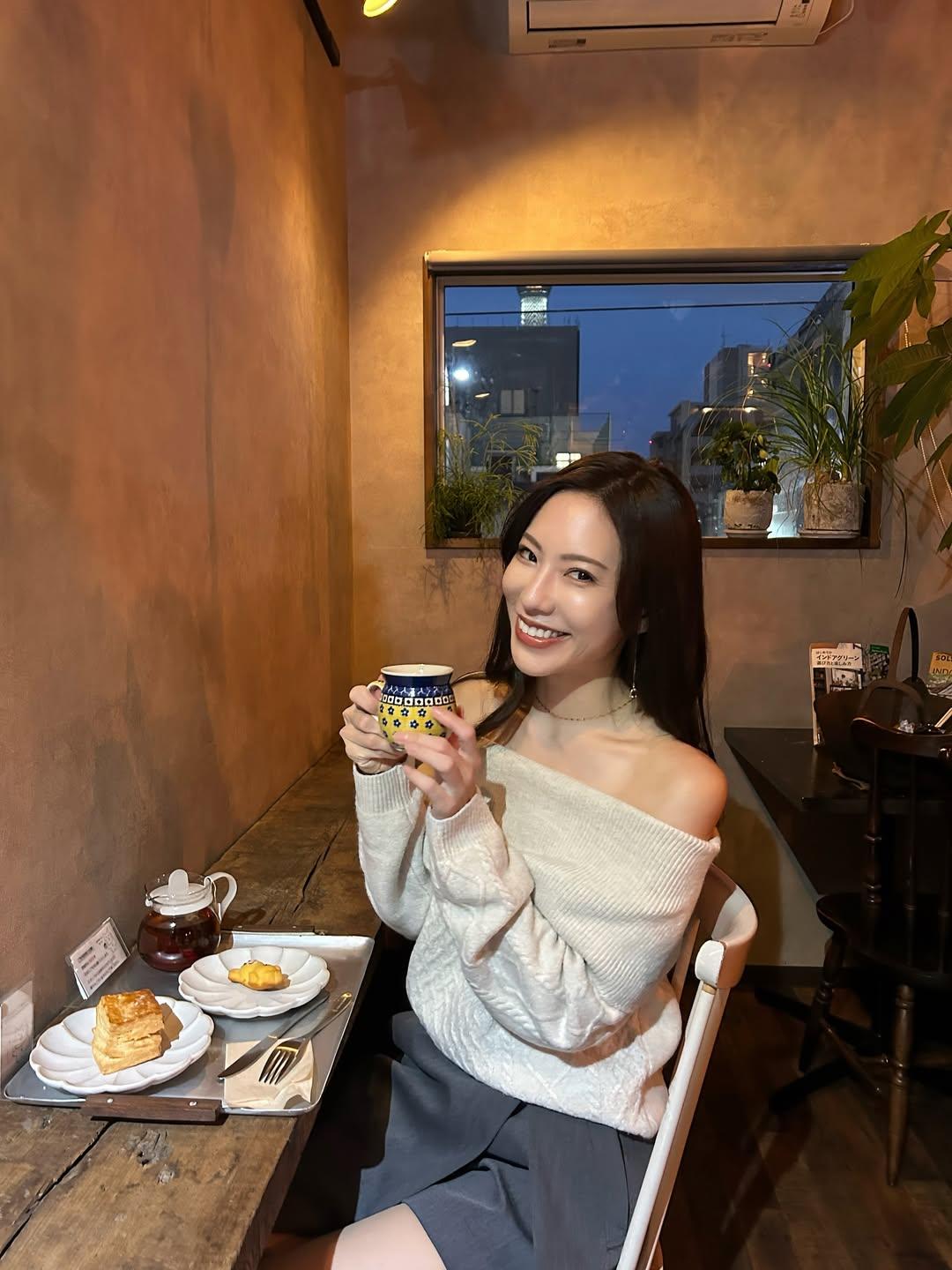 就像李嘉欣在伦敦的咖啡馆，白色上衣配米色外套，旁边摆着精致糕点和饮品，妥妥的贵族