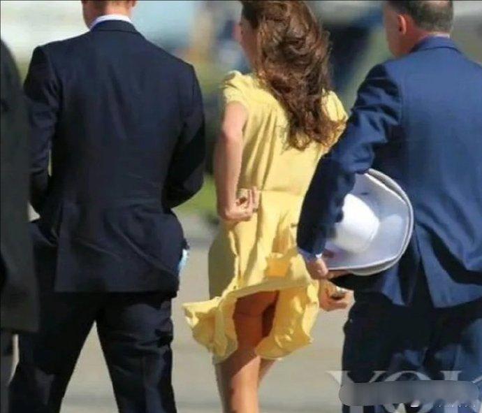 凯特王妃，在某次访问活动中，意外地遭遇了一阵风，风将她那黄色连身裙轻轻吹起。就在