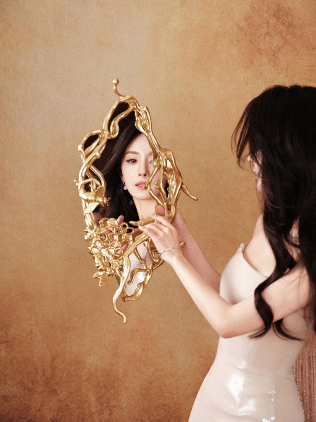 真的被杨幂这组新图美到失语！手握鎏金艺术镜，肩头指尖停驻着金色蜂鸟饰件，在暖调光