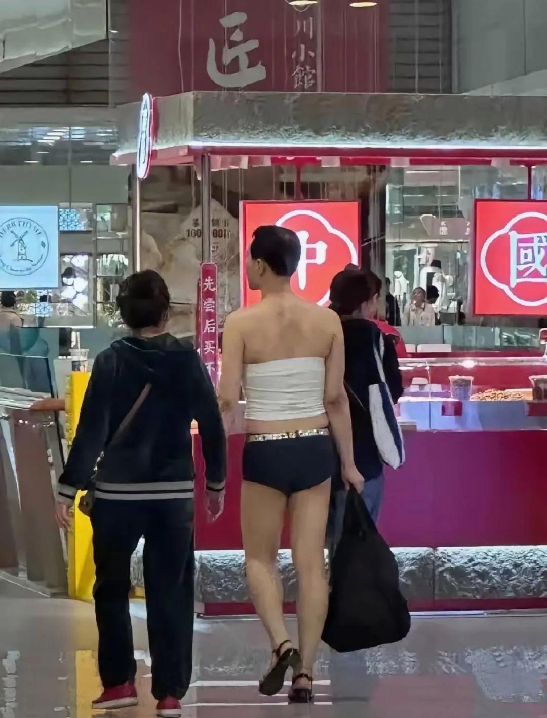 这在大街上逛街的露背装是男是女啊？这性感妖娆的样子，一般人不敢穿吧，胸部裹着一条
