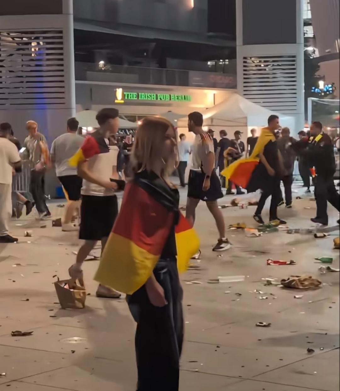 德国队点球被巴拉圭队击败后，柏林一处广场上，聚在一起看球的人们，无法接受大屏幕里