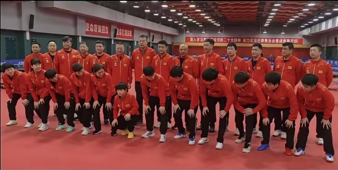 这张合照里莎莎妥妥是可爱显眼包😂
前面一排队员都半蹲着看向她，就莎莎一个人乖乖