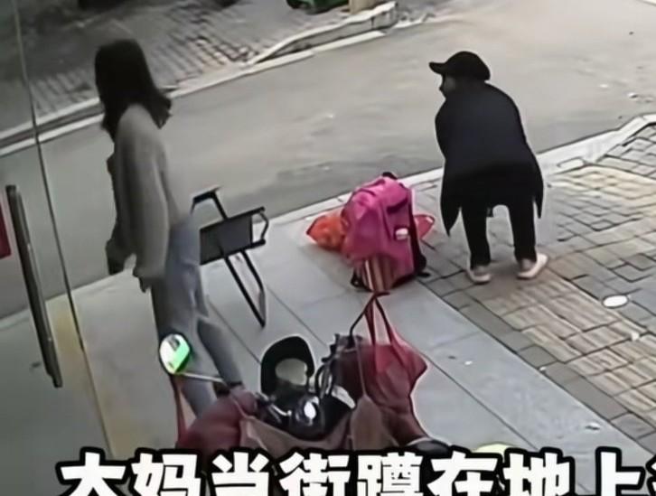 大妈在一店门口前等人，漂亮店主看大妈蹲着很累，
就从店里拿了一把椅子出来，让大妈
