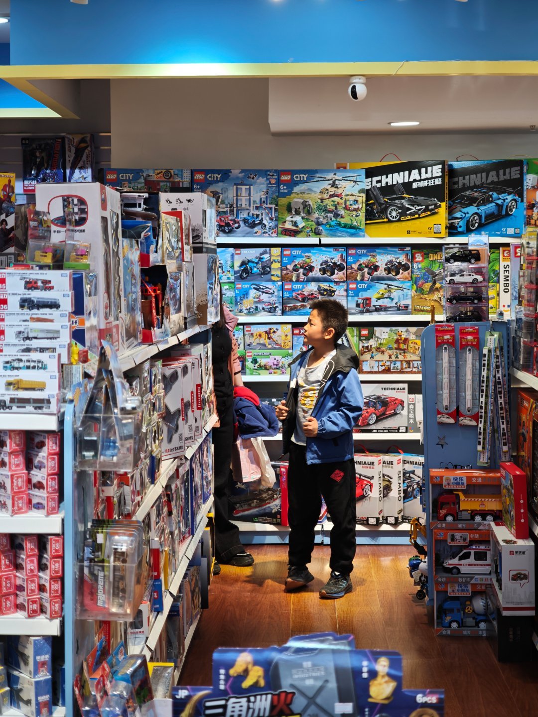 玩具店遇到一位小学生居然跟我小时候一模一样他在TOMICA展柜挑了半天她妈妈只允