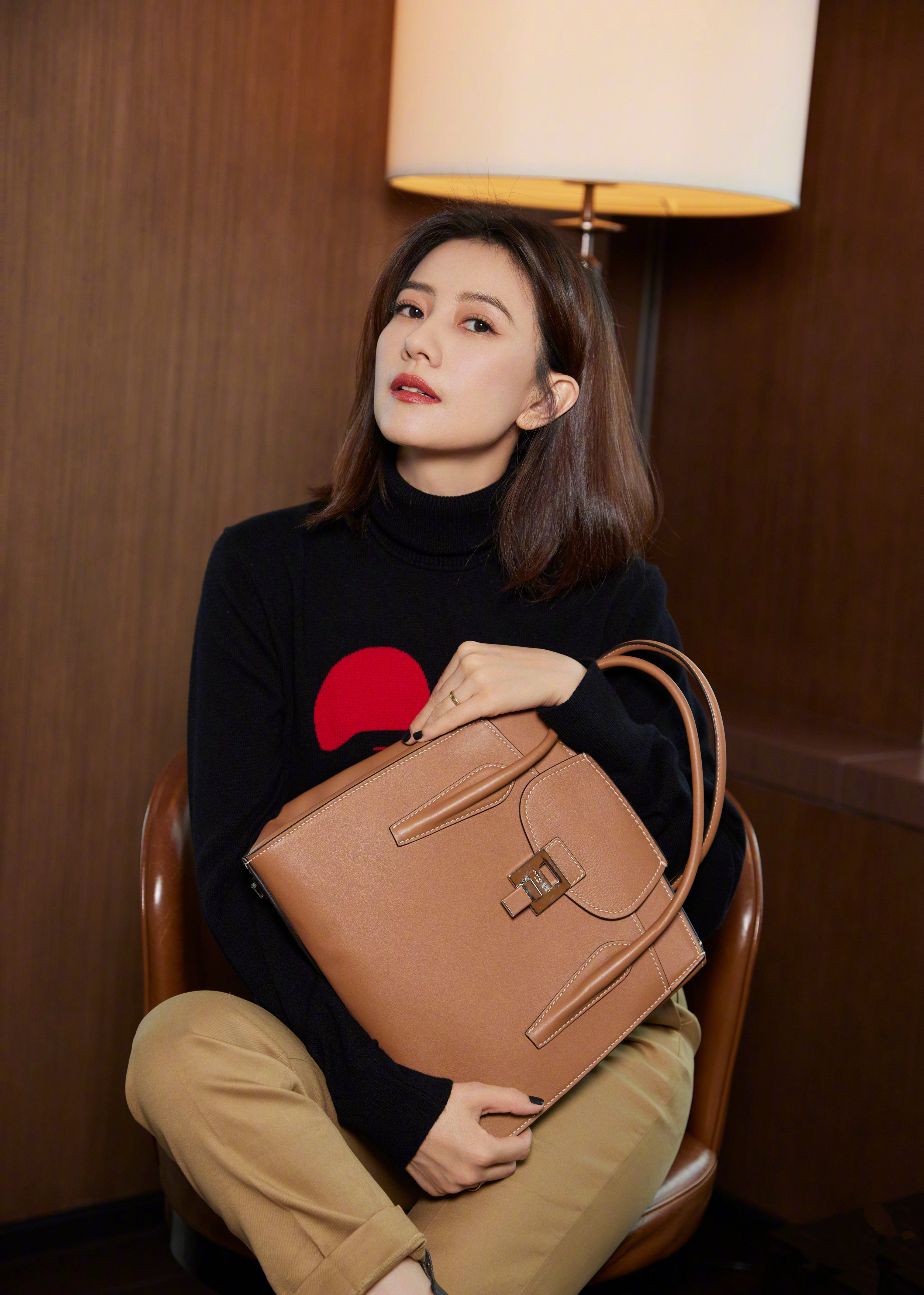 这组造型尽显成熟女性的优雅韵味，黑棕配色简约高级，慵懒坐姿衬出松弛气场，眉眼间的