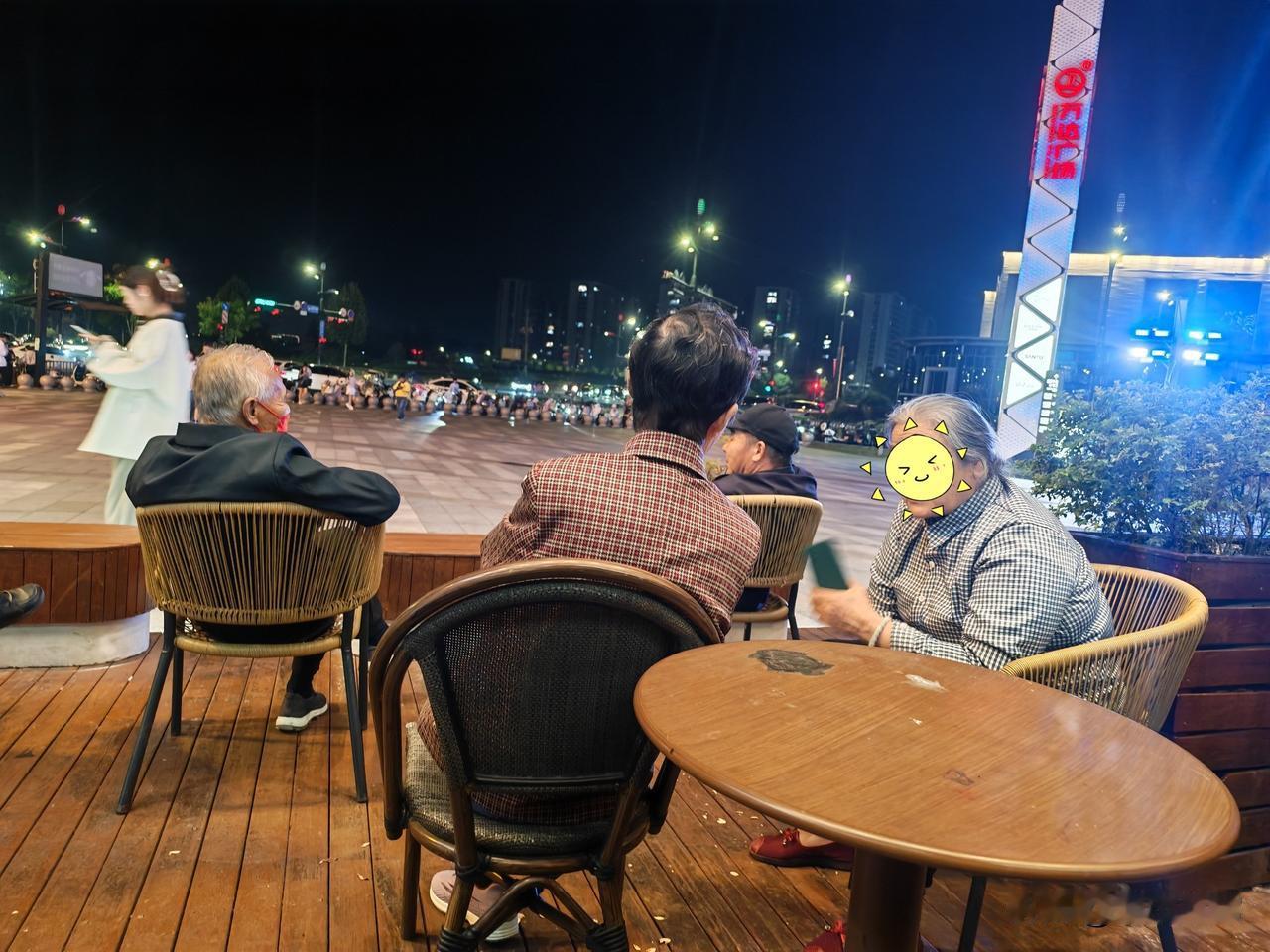 万达广场门前的休息区，坐着几个白发苍苍的老头老太太。他们是附近的居民，每天晚饭后