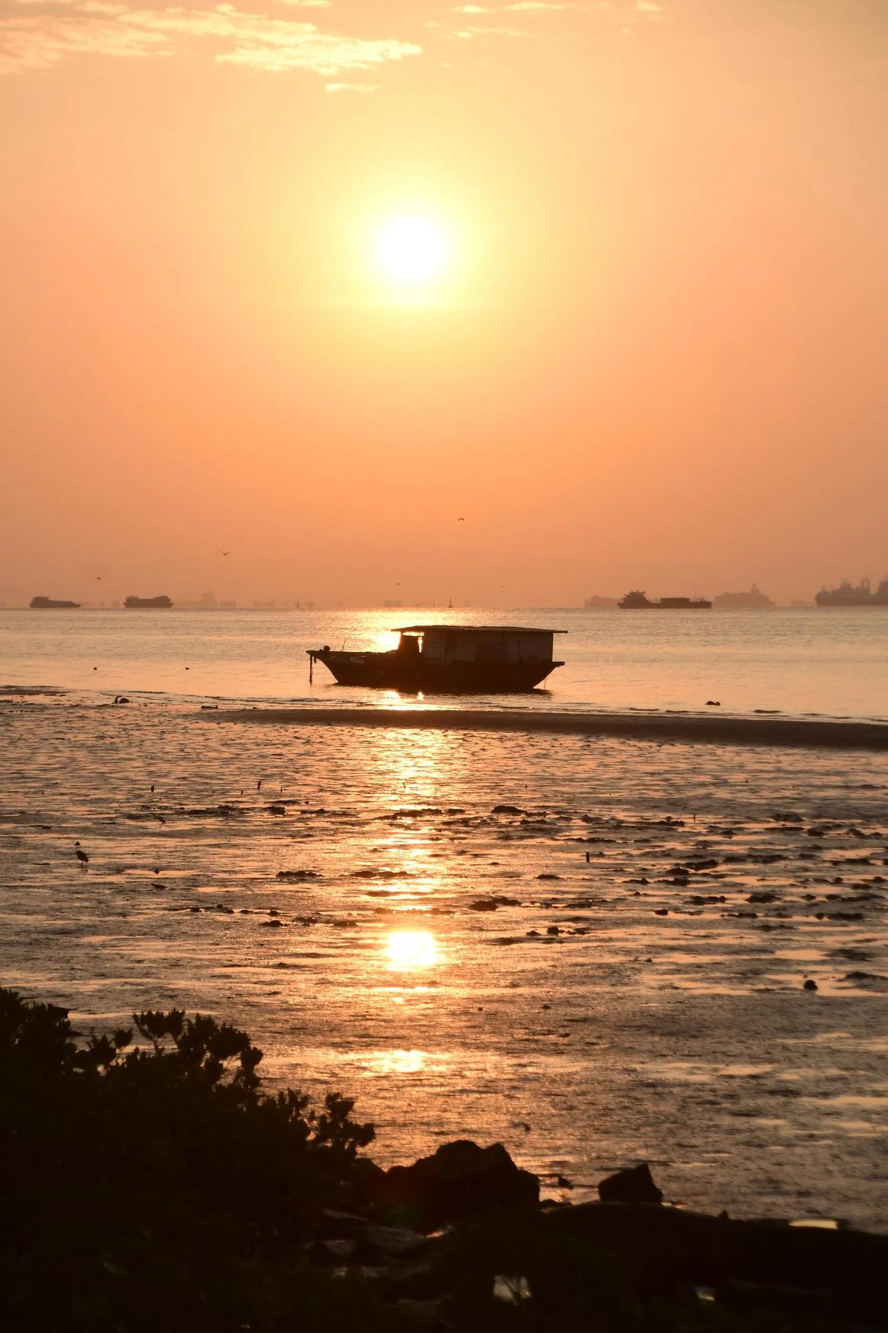 落日余晖，海天一色，静谧的海面，小船悠然航行。落日照海域 拍海上日落 落日下的海