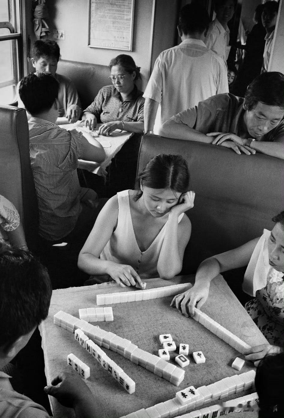 1994年，北京到沈阳的火车上旅客在打麻将的场景，十分的悠闲自在。当时，北京到沈