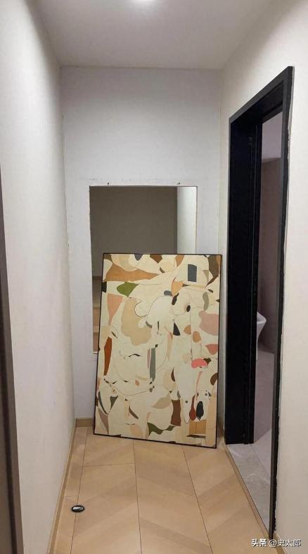 武汉一家loft酒店内，女子拿烧水壶时不慎撞歪墙上装饰画，好奇取下后直接傻眼：画