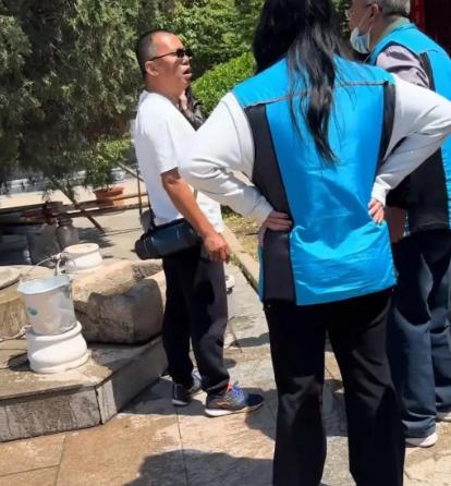 险些浪费！5月3日，青岛灵珠山菩提寺内，一名白衣男子带儿子欲倒掉桶中满装的山泉水