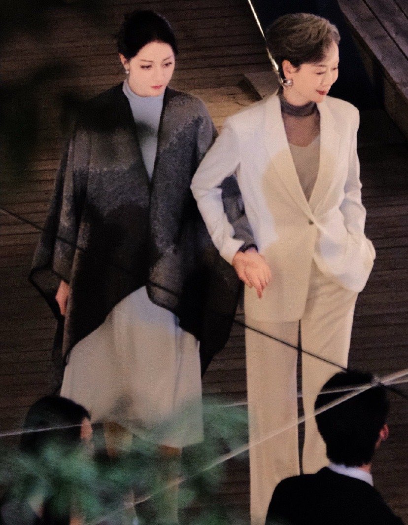 迪丽热巴一袭卫蓝白裙，清新灵动。她轻轻脱下披肩，瞬间切换至角色状态，眼神专注而投