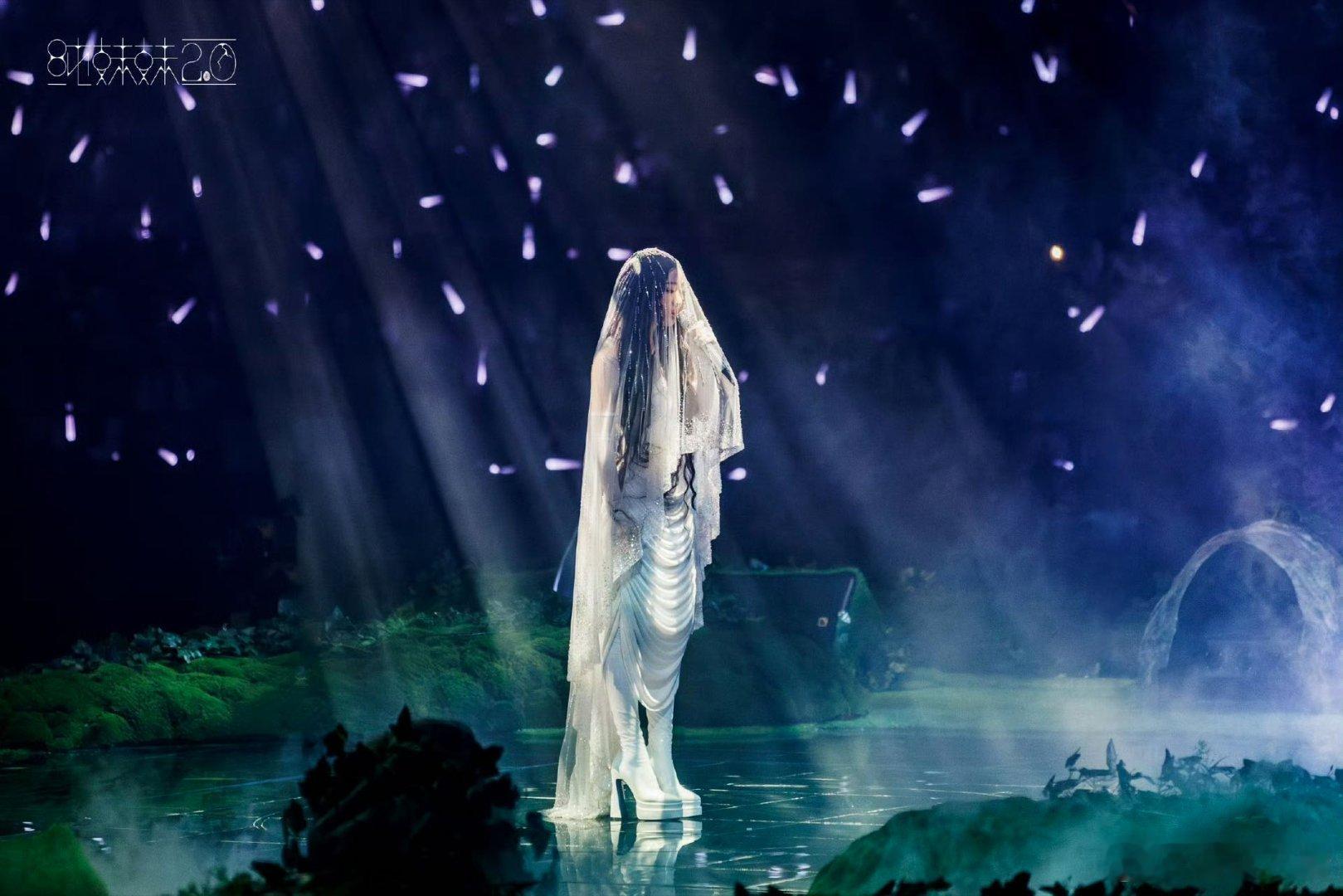 纱裙流转似月光倾泻，麦克风是点亮星河的权杖，红装如焰燃烧舞台，每帧都是流动的诗篇