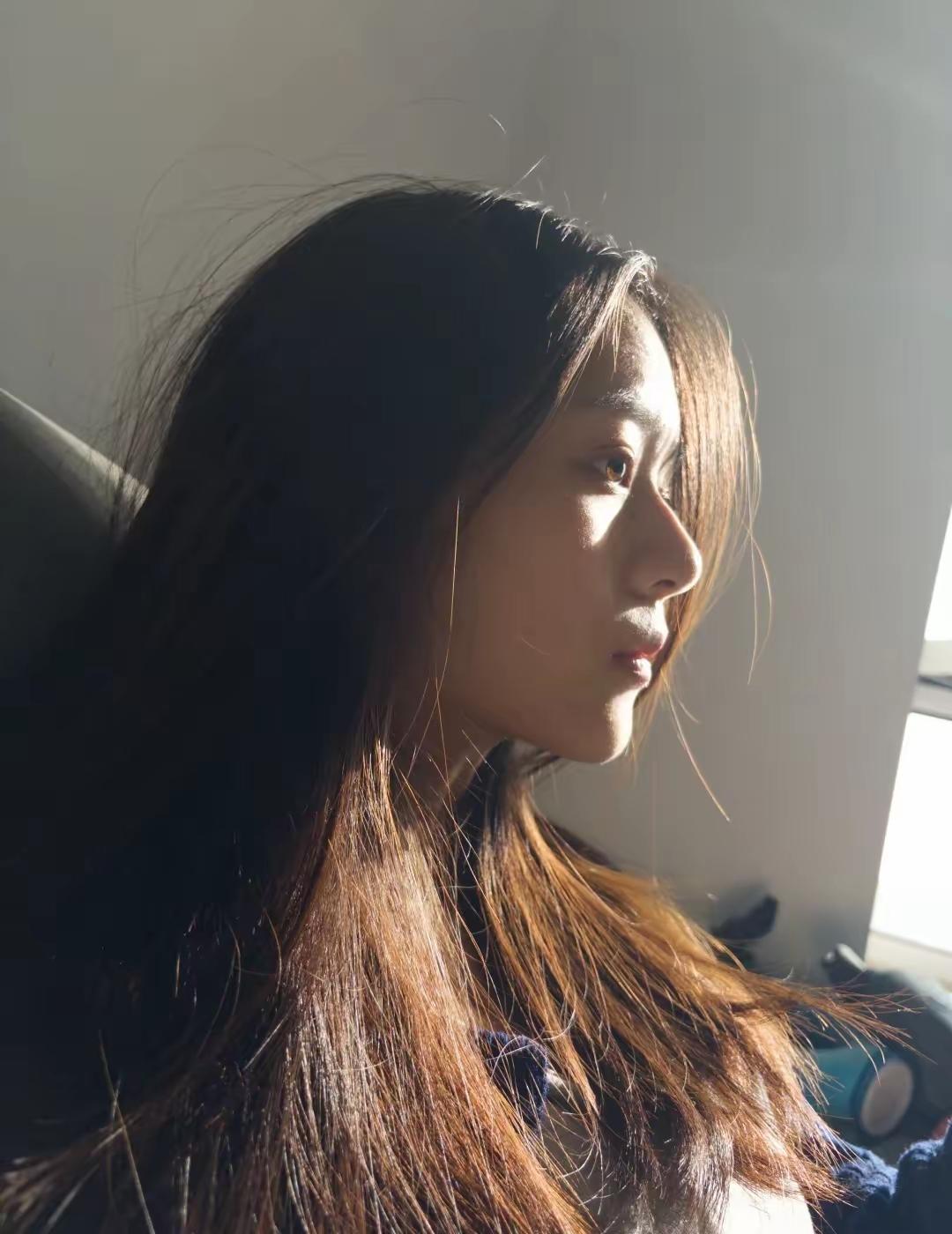 阳光洒进房间，照亮了她的侧脸，温柔而宁静。阳光少女照 久违阳光照进来 温柔照片