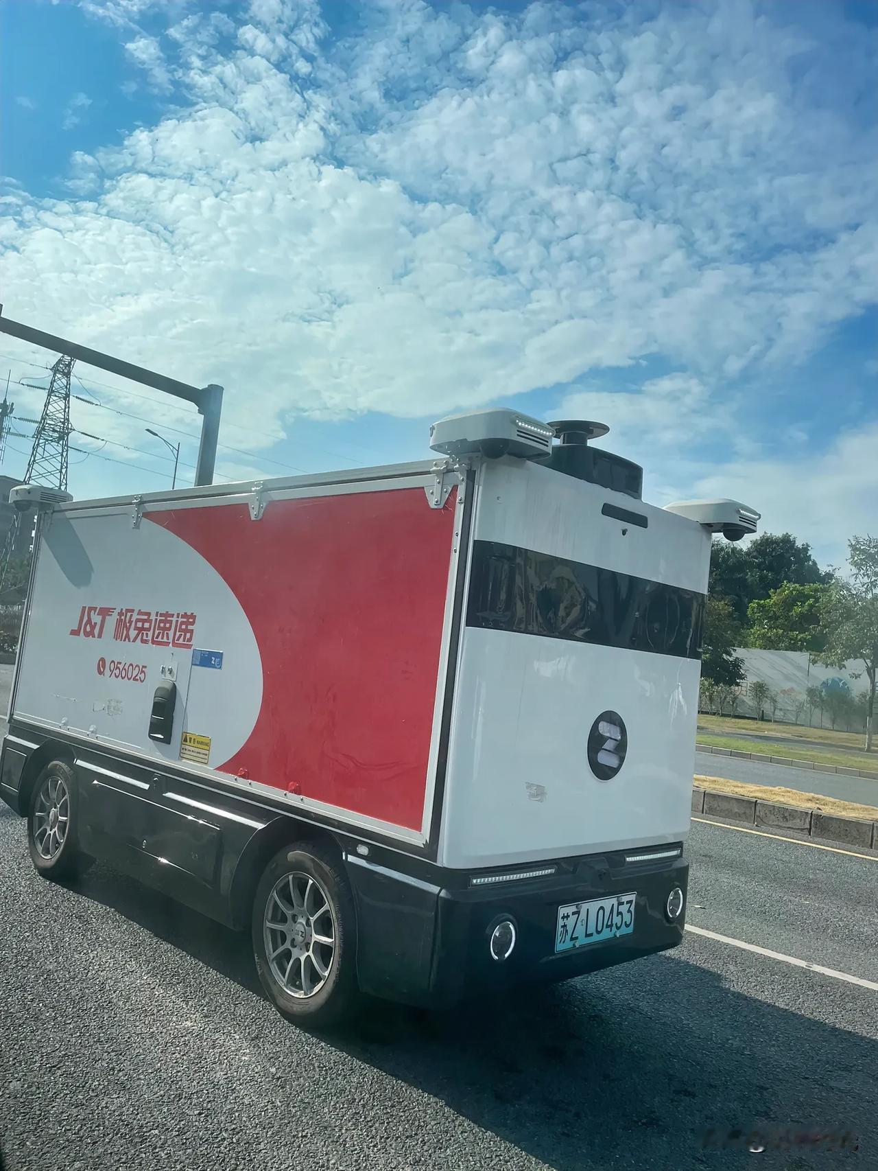 龙岗区碧新路偶遇一样貌奇特的快递车，看起来好像是无人驾驶的，但又是有车牌的，还是