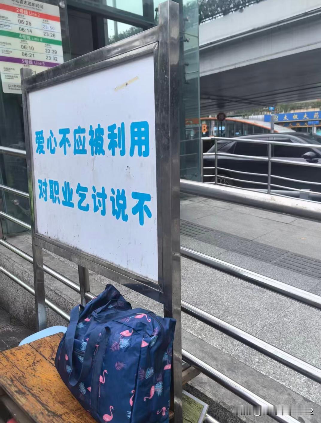 医院地铁口周围乞讨扎堆堆，旁边有个牌牌很醒目。