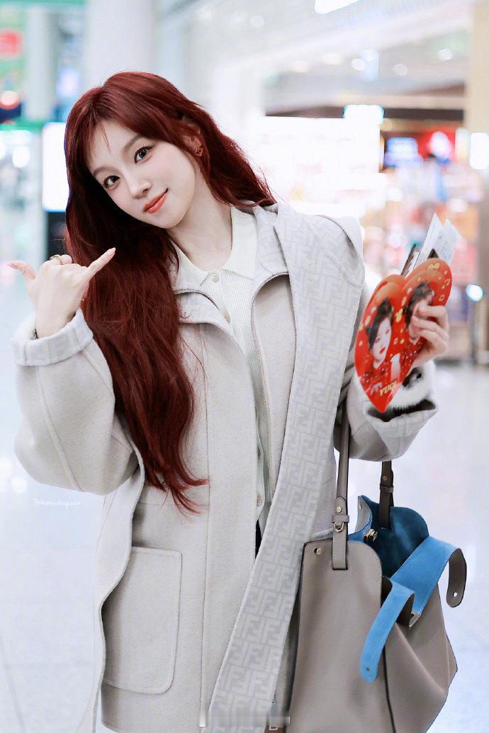 宋雨琦拿了自己的小福娃手幅 宋雨琦飞米兰，机场接过粉丝递来的手幅——上面印的是她