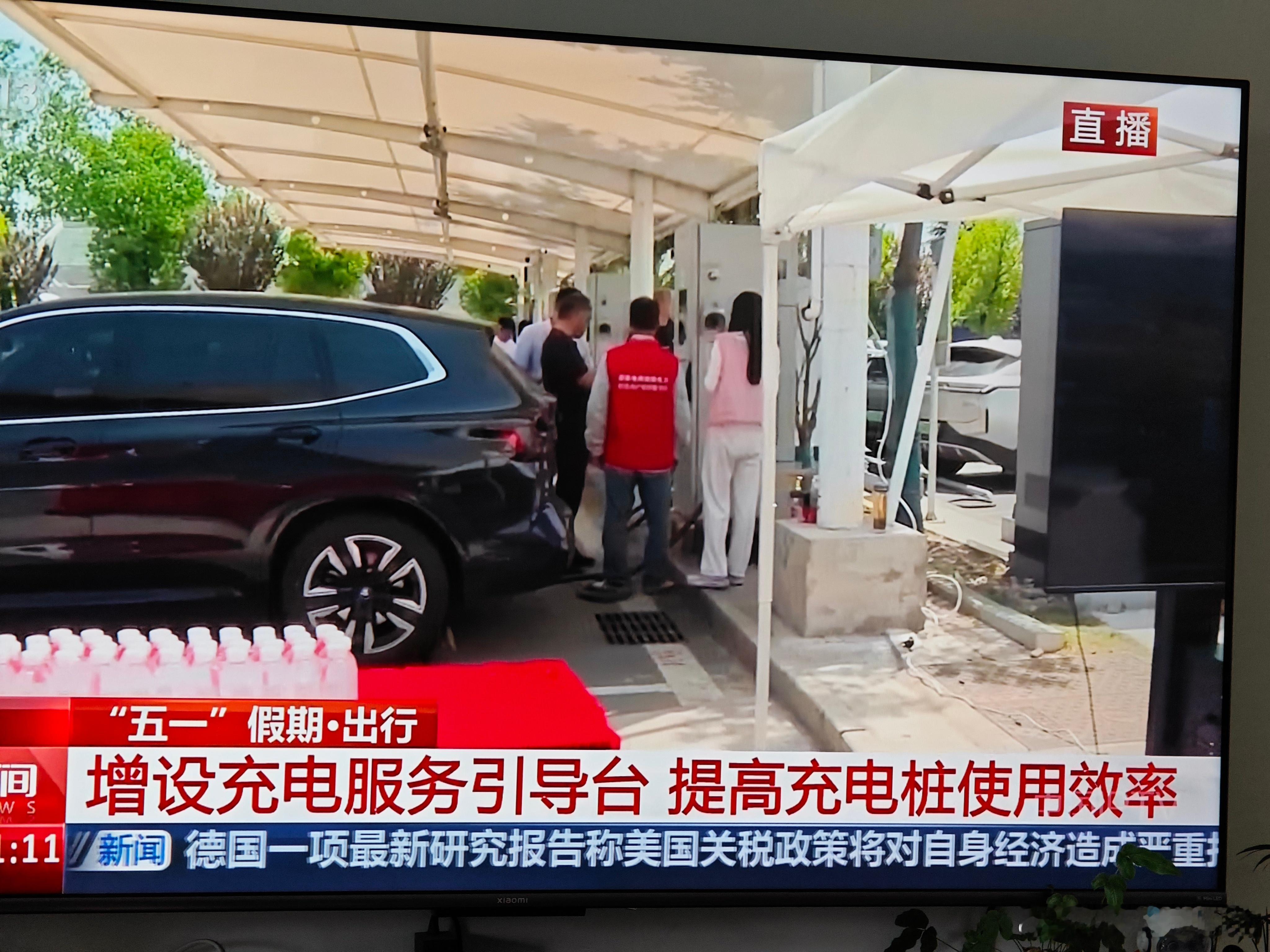早上看央视新闻，五一假期充电高峰期，充电桩增加充电服务站，现场有人维护秩序。镜头