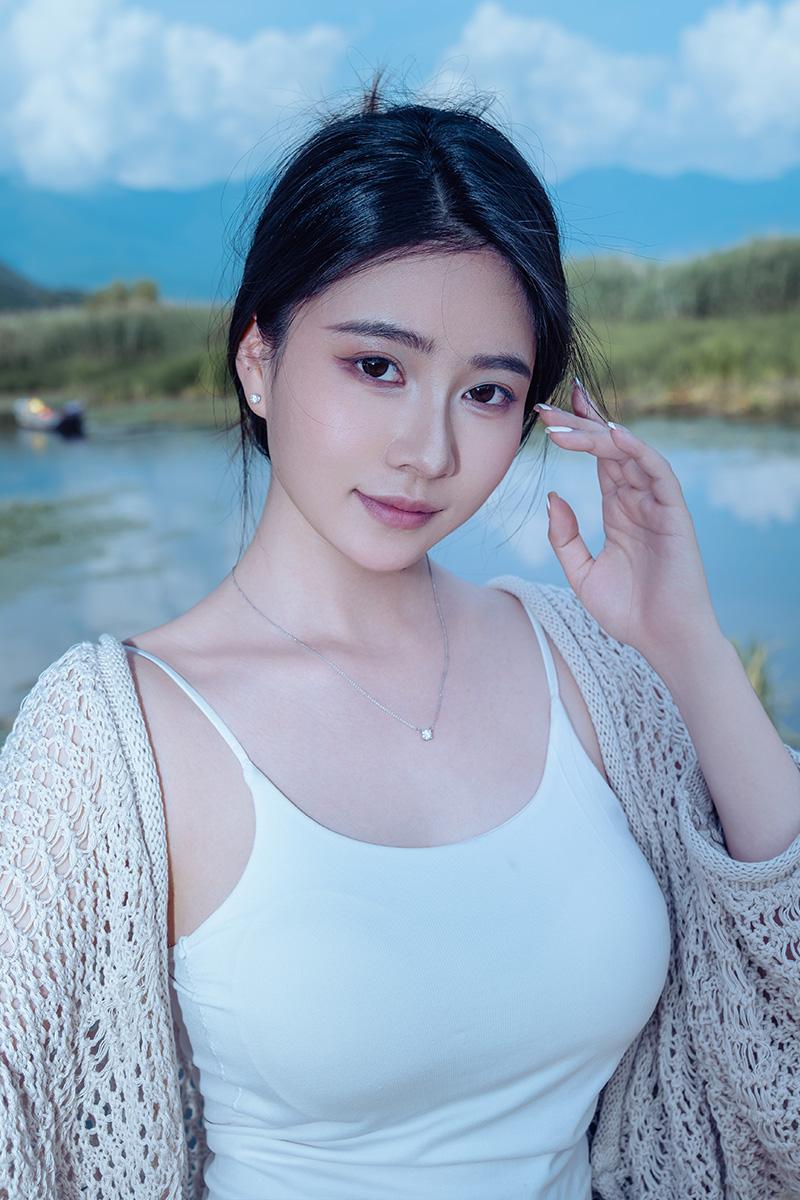 一个漂亮姑娘在湖边自拍。