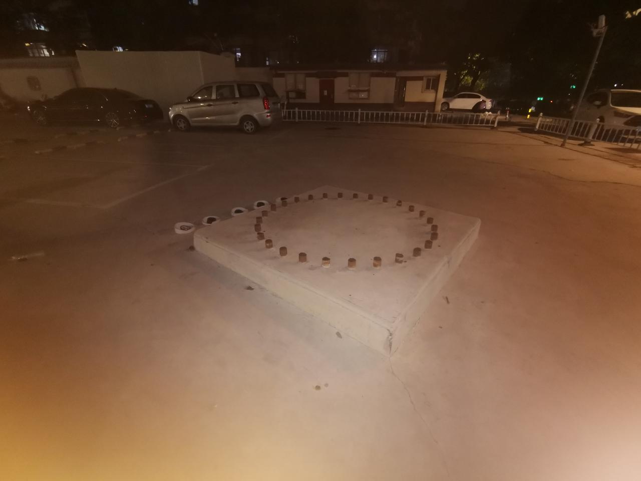 这是一个电力铁塔拆除后留下的。就在地铁口的停车场，也是出地铁后行人的通道。因为电
