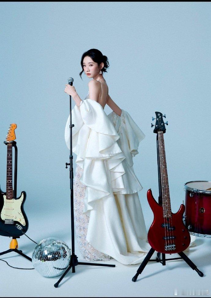 张艺凡弹完你的弹你的张艺凡白色亮片挂脖长裙，一手轻执鼓槌，一手扶鼓，优雅又漂亮，