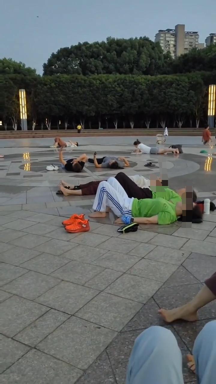 炎炎夏日，躺地上能治病？海宁一个公园广场，每天下午5、6点钟，就有一群人躺在广场