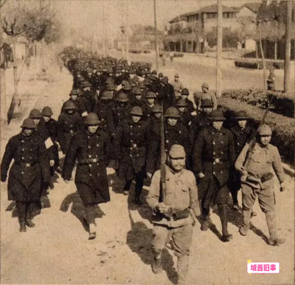1937年，南京沦陷后，日军押着一群被解除武装后的南京警察，准备前往汉...
