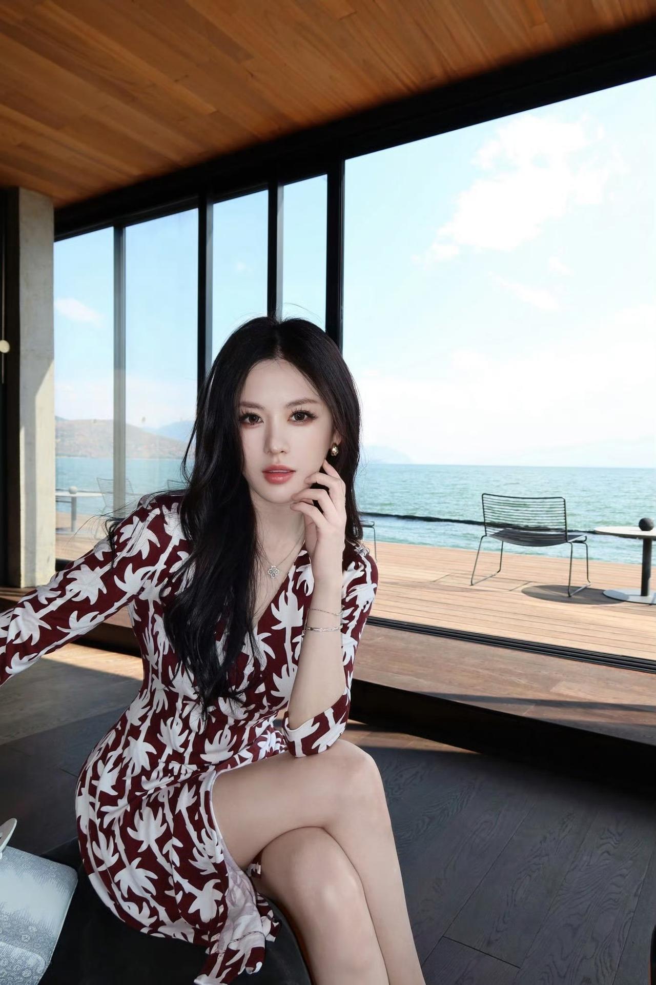 落地窗揽一整片澄澈海色，红棕椰影裙勾勒从容线条。

微风漫过海面，阳光落于肩头，