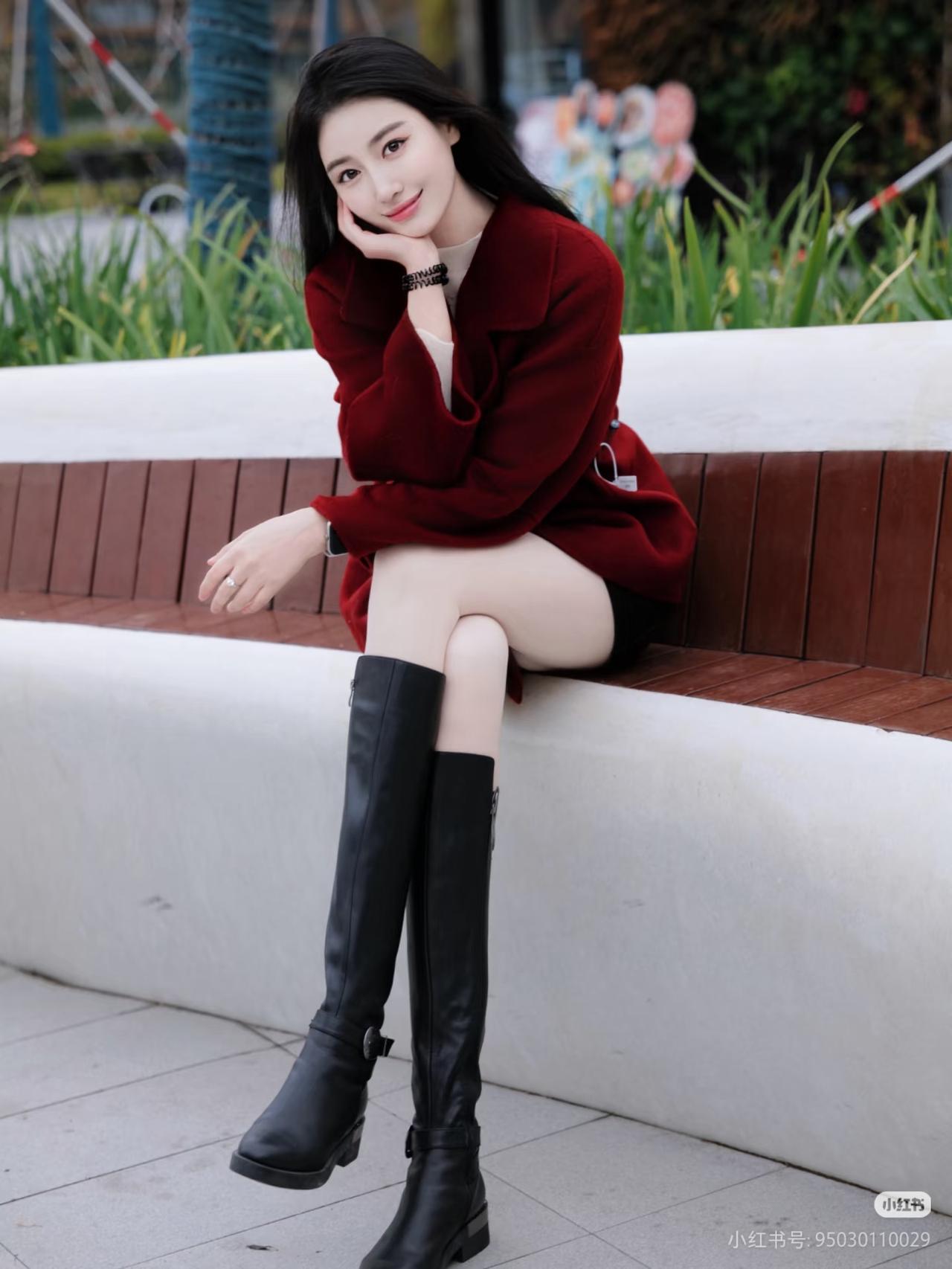 冬日暖阳下，红衣少女倚栏笑，黑靴相伴，岁月静好。