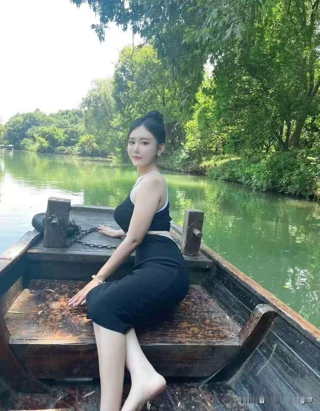 夏日乘舟，轻摇扇子，悠然自得。