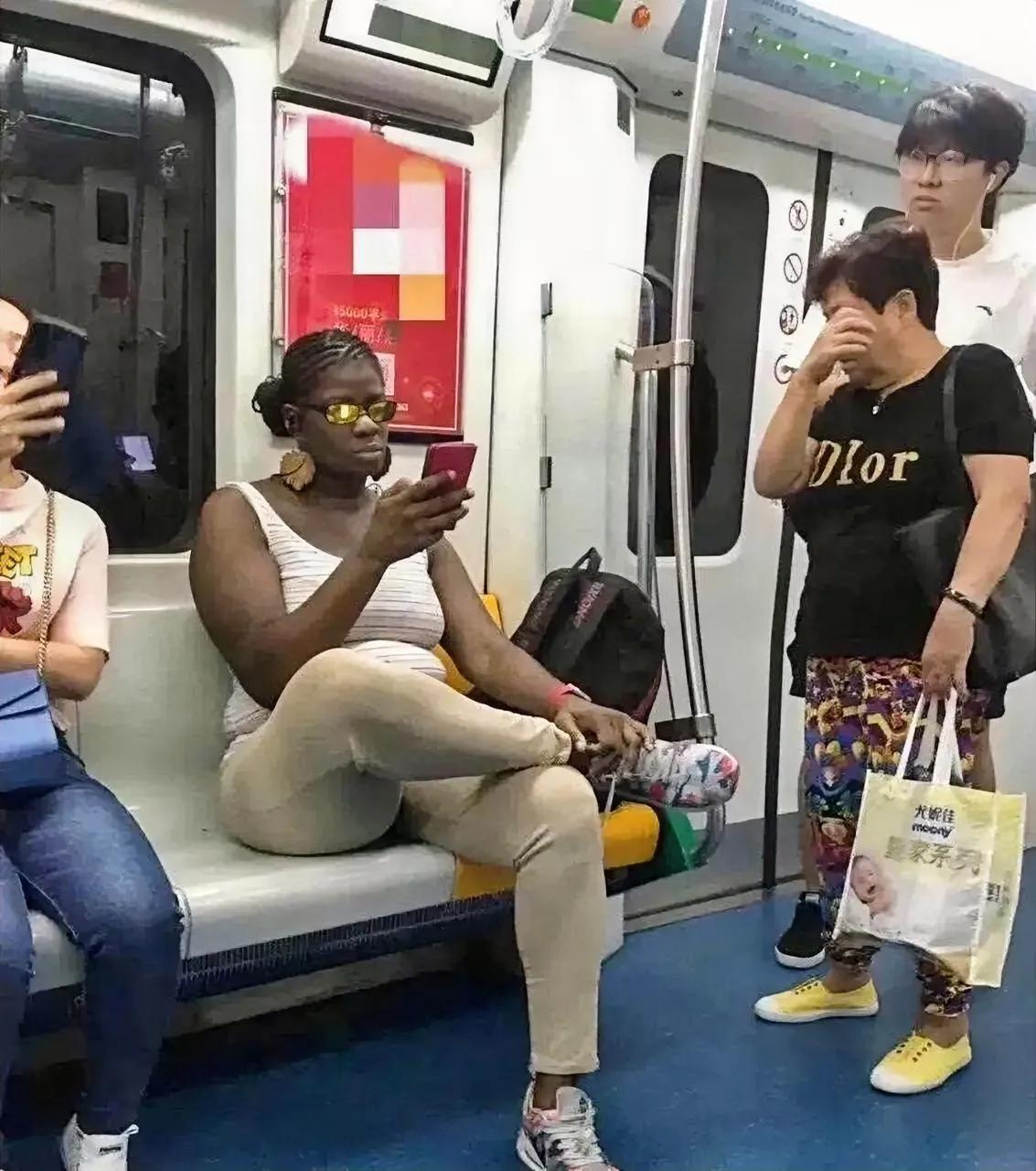 这是地铁上的一幕，大妈敢怒不敢言。

一个人高马大，体型壮硕，戴着墨镜，刷着手机