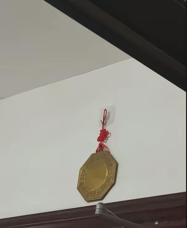 昨天去一位朋友新家做客，走到门口发现，对门邻居的门楣上挂了一面铜镜，正对着朋友家