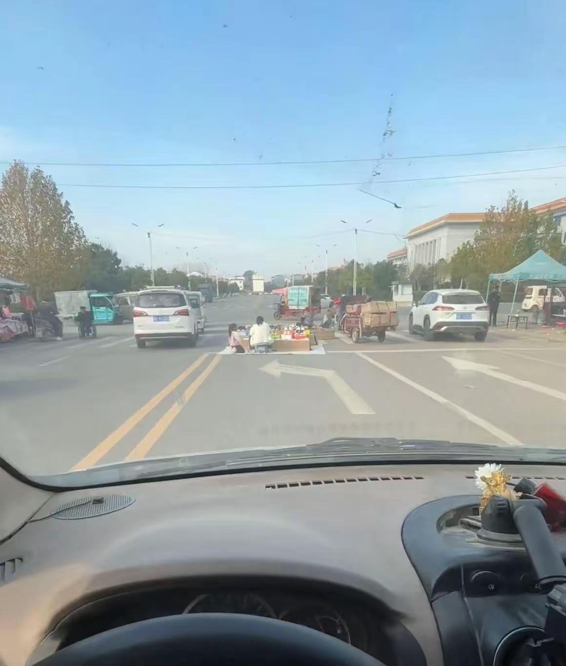 这年头摆摊都摆出新境界了。河南驻马店有位摊主，直接把摊位支到了马路正中央的斑马线