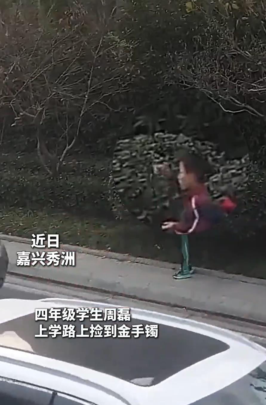 火到新华社了！浙江嘉兴，一名小学生在上学路上看到路边有个金光闪闪的东西，上前捡起