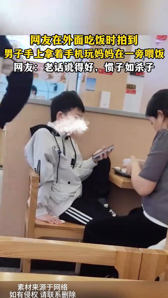 网友在外面吃饭时拍到男子手上拿着手机玩，妈妈在一旁喂饭。
网友：老话说得好，惯子