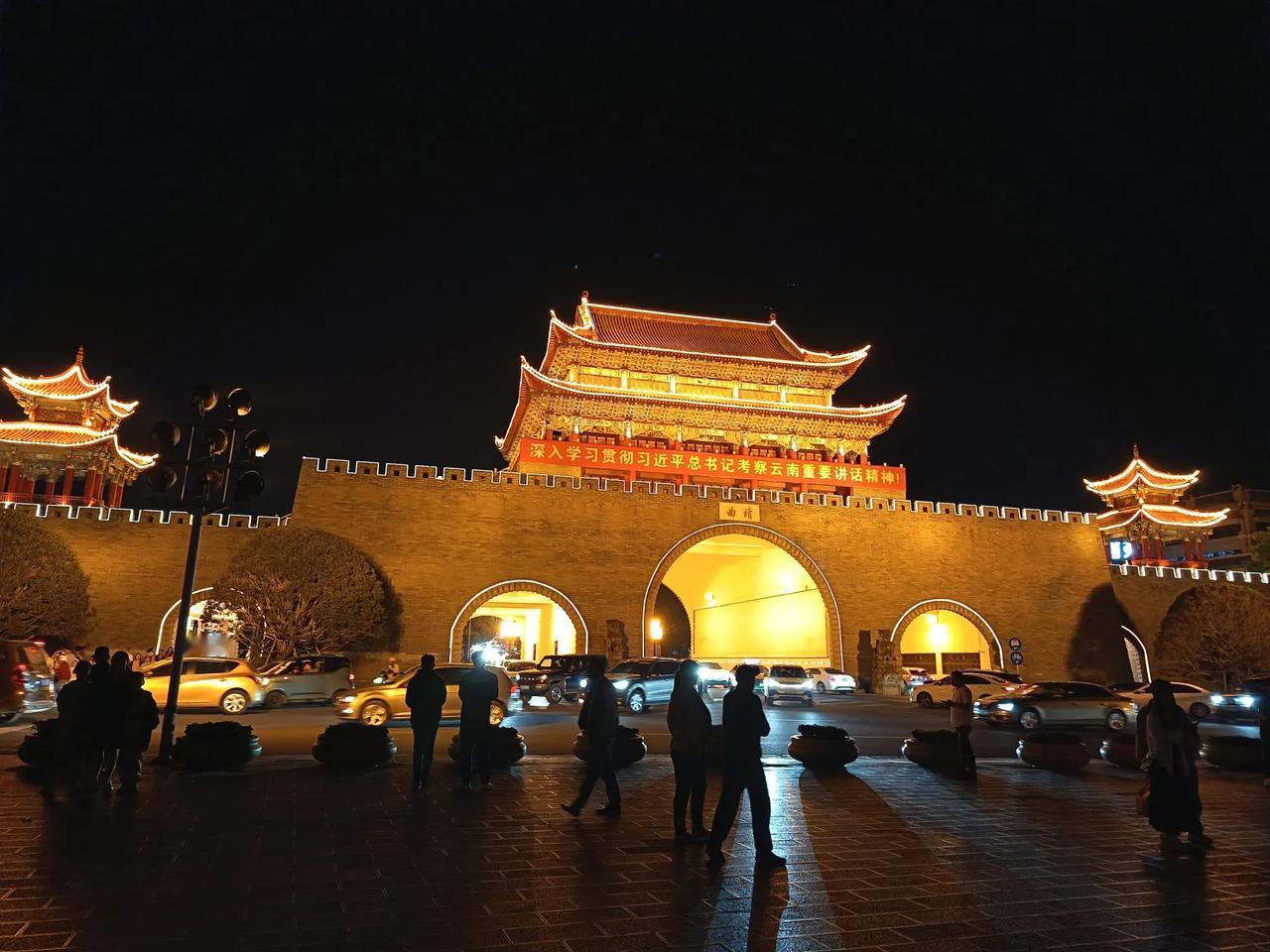 夜色中的南城门，在灯光的映照下显得雄伟而金碧辉煌。川流不息的车辆，在广场上散步和