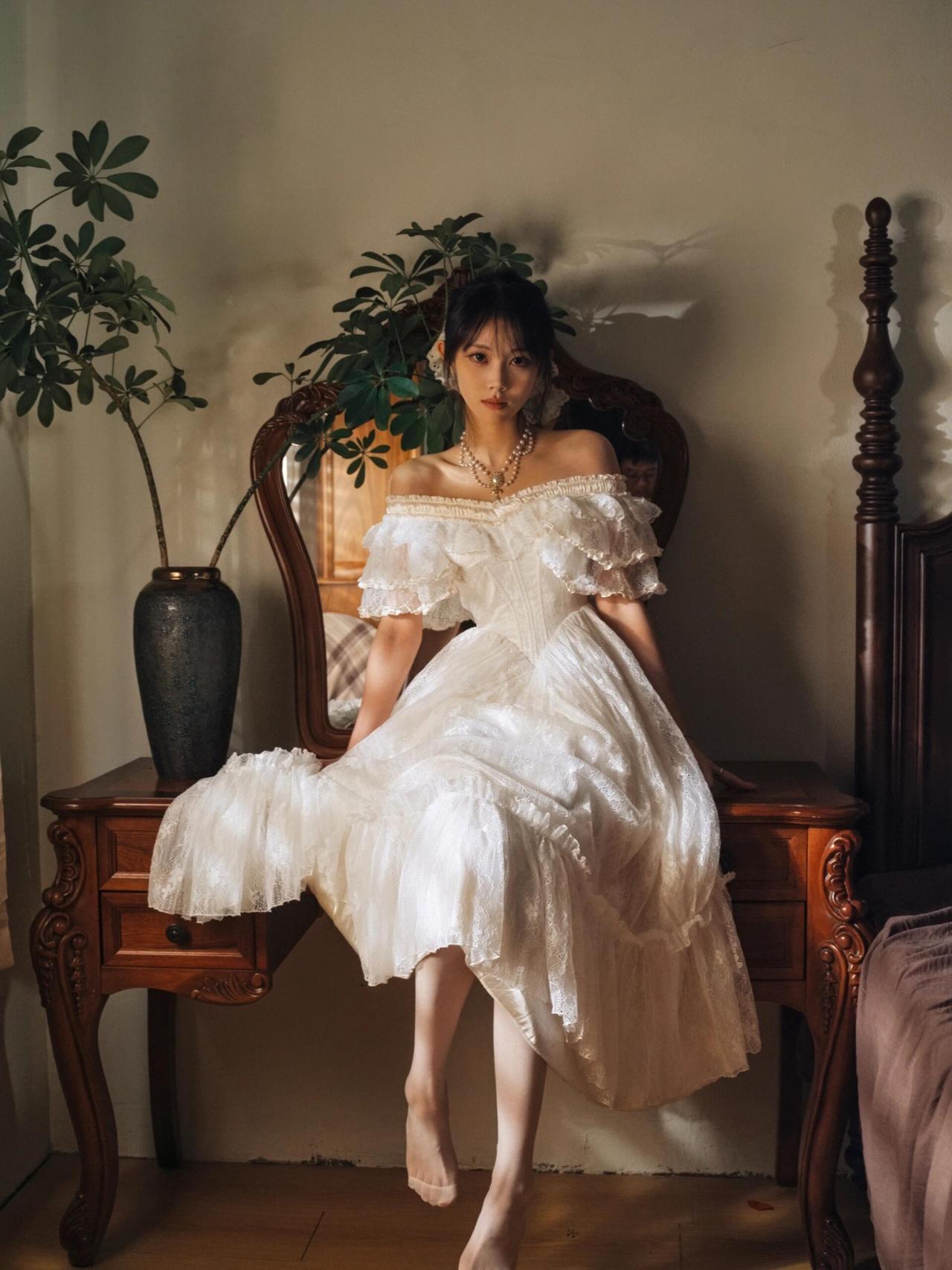 场景中的细节道具为叙事添彩，翻开的旧书、摆置的干花、复古铜镜与画框，这些物件并非