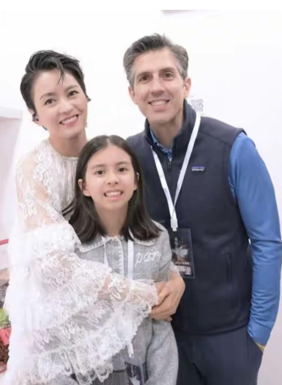 让我们一起来欣赏一下梁咏琪的全家福吧：

镜头中的梁咏琪身着白色蕾丝长袖上衣，短