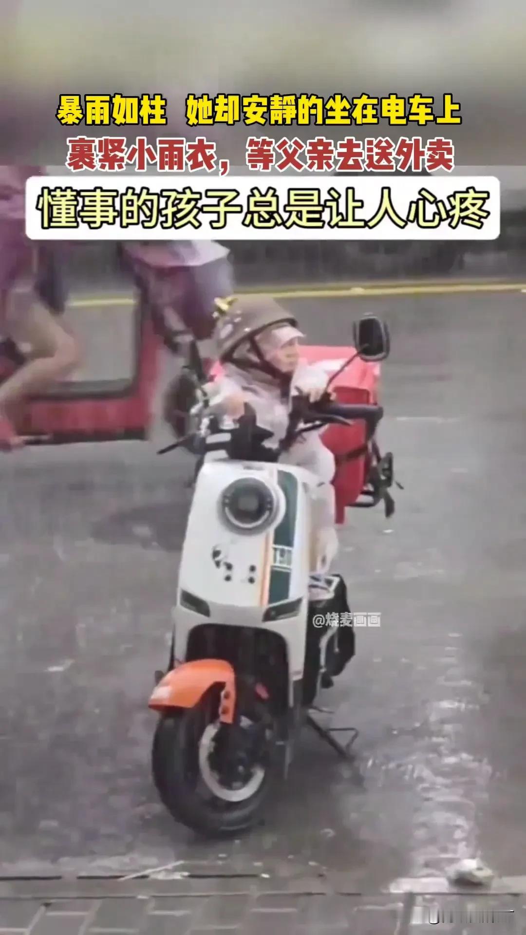 暴雨倾盆的时候，路面上的积水漫过了电动车的轮胎。
 
穿雨衣的父亲骑着车，后座裹