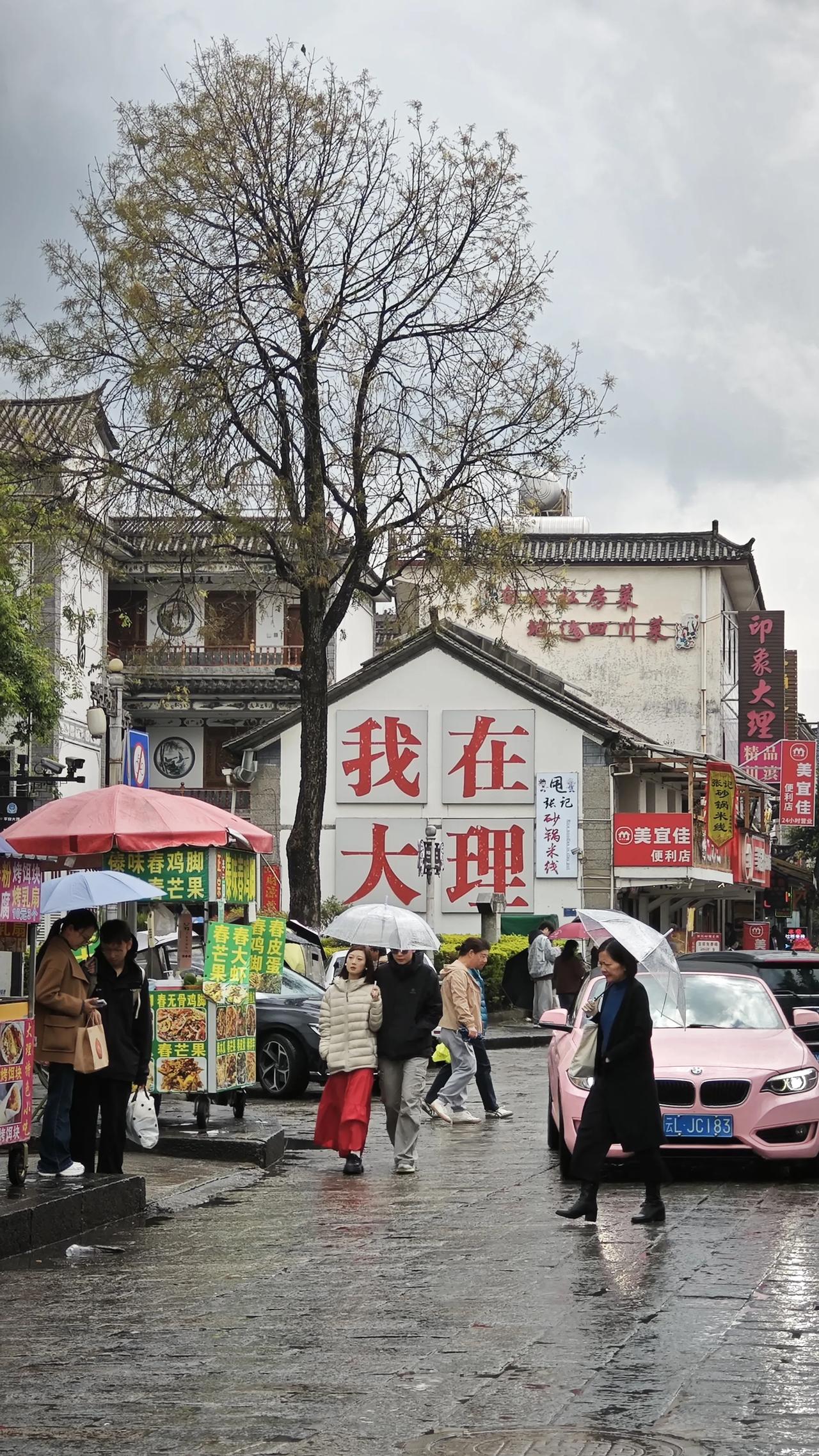 今日分享随手拍照片雨后的大理，青石板路泛着湿润的光，行人撑着伞慢悠悠走过。“我在