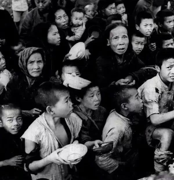 1946年，湖南常德，大饥荒期间，饥饿的灾民们，手里拿着空碗，正在焦急的等待着派