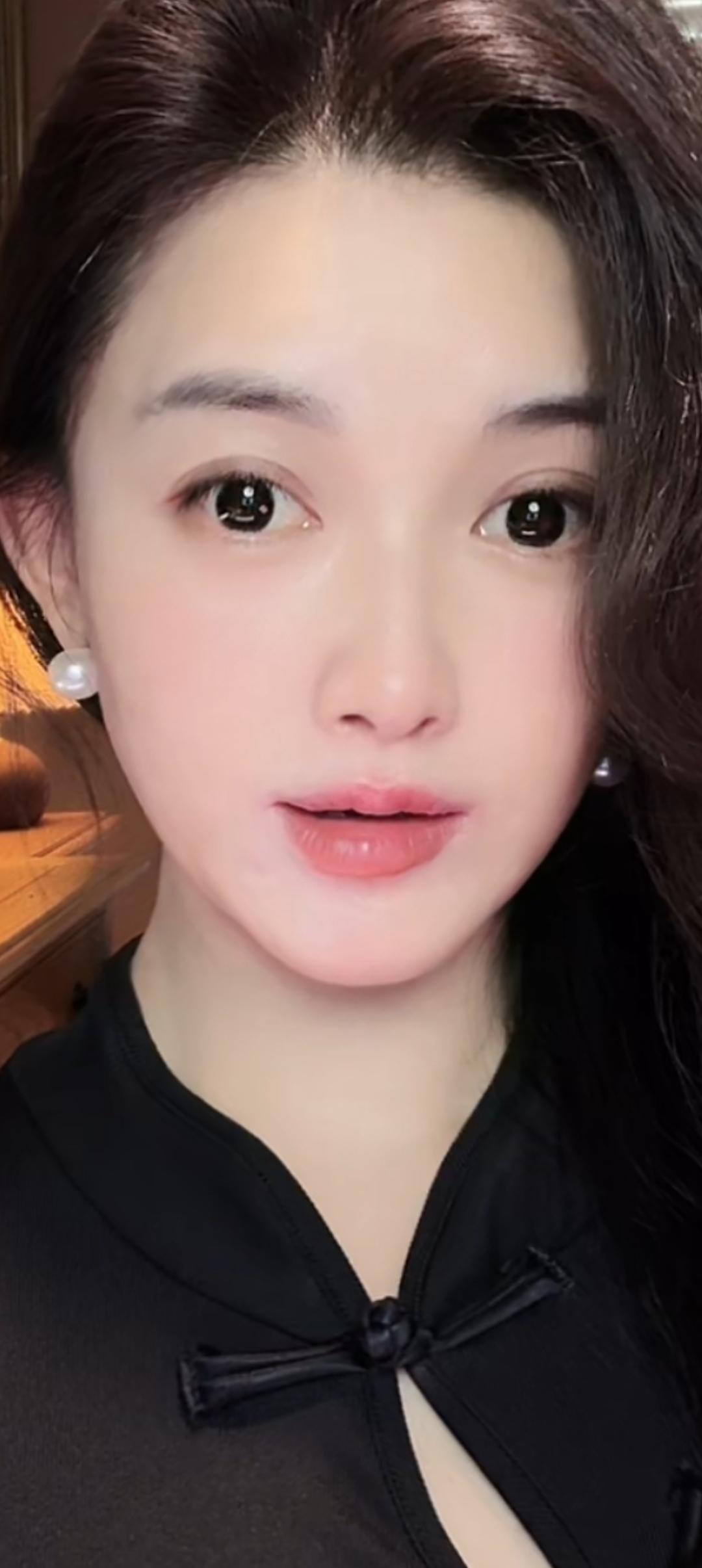 这位小姐姐穿着黑色上衣，佩戴珍珠耳环。