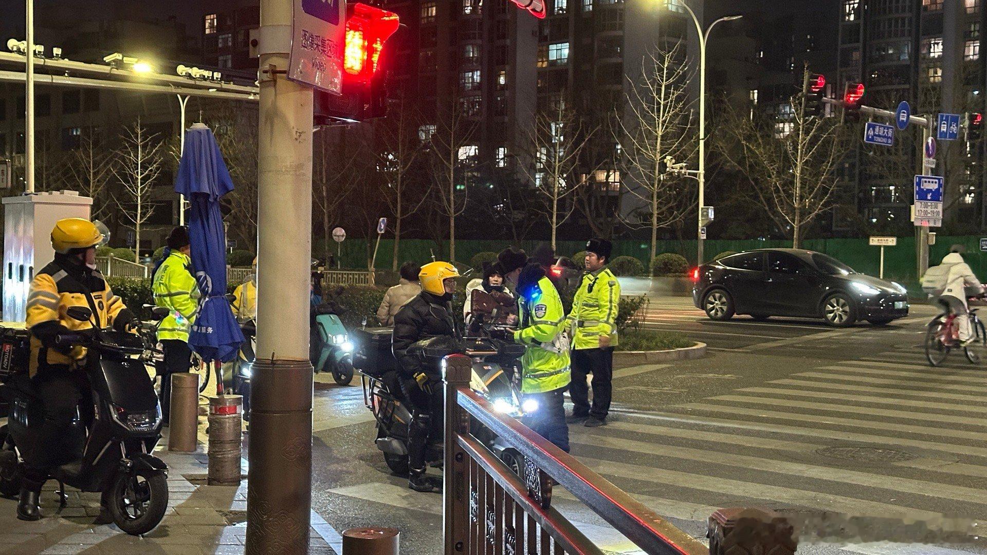 在通州通胡大街和紫运中路交叉口，交警拦下了行驶在机动车道上骑着电动车的人，然后大