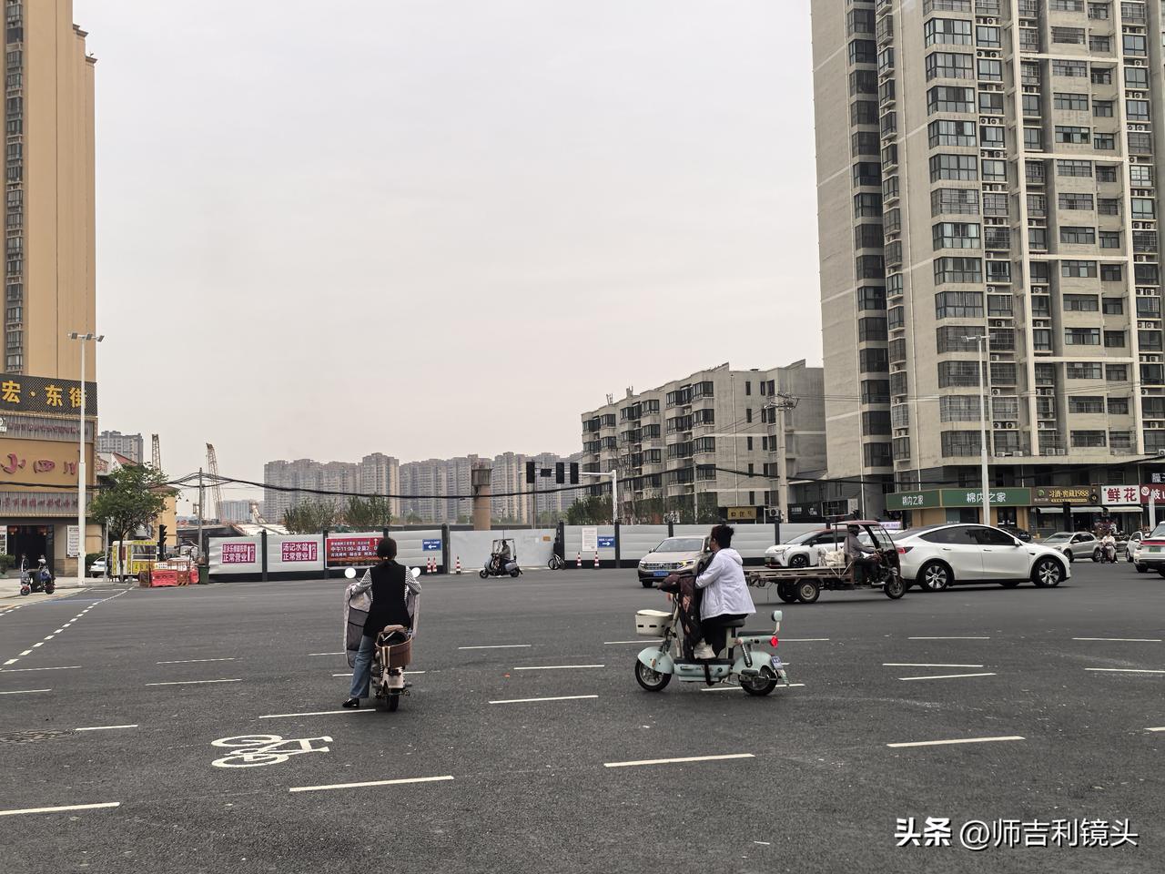 当时，路口有两个骑电动车的人看着前方，用手向前方指指点点相互说着什么。小编也不由