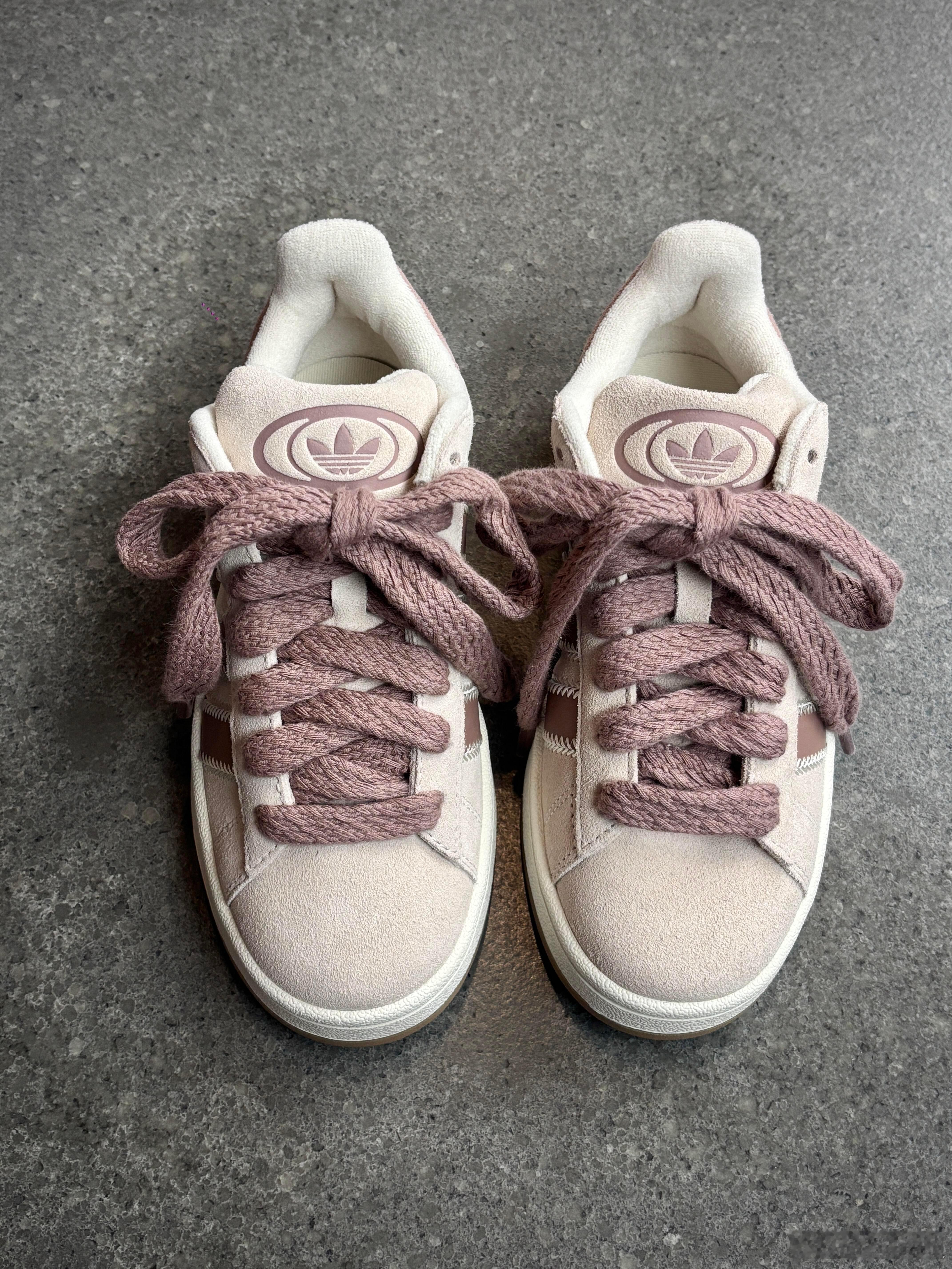 这双阿迪达斯CAMPUS系列运动鞋以柔和的浅粉色为主调，搭配白色细节，整体呈现清