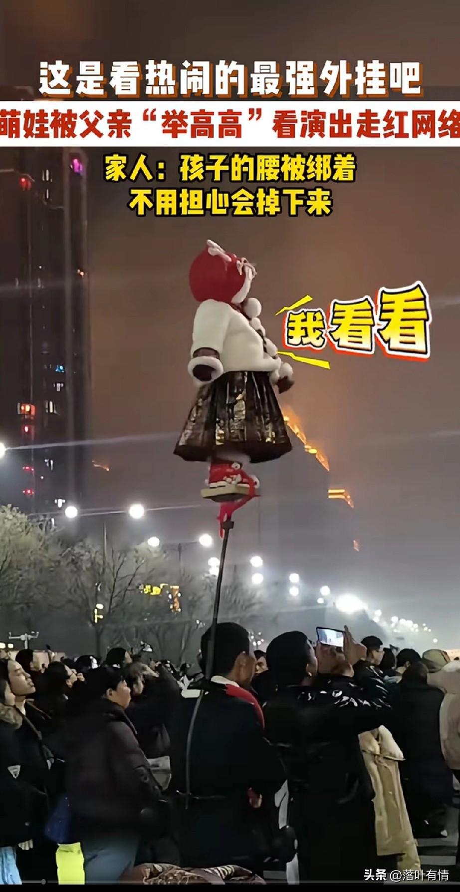 萌娃被用棍子举了起来，
在人群中格外显眼，
因为这样反而走红了，
网友都说这是最