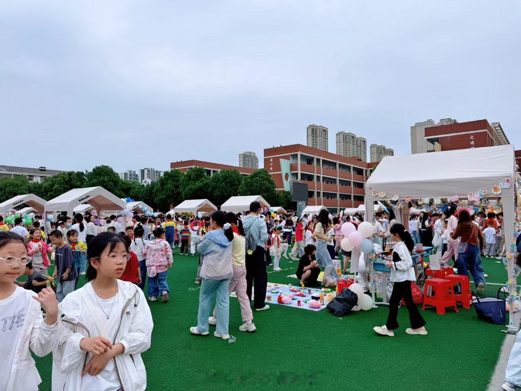 今天学校搞“义卖集市”，我找了一个零食店换了20块钱给闺女。老师发活动照片到群里