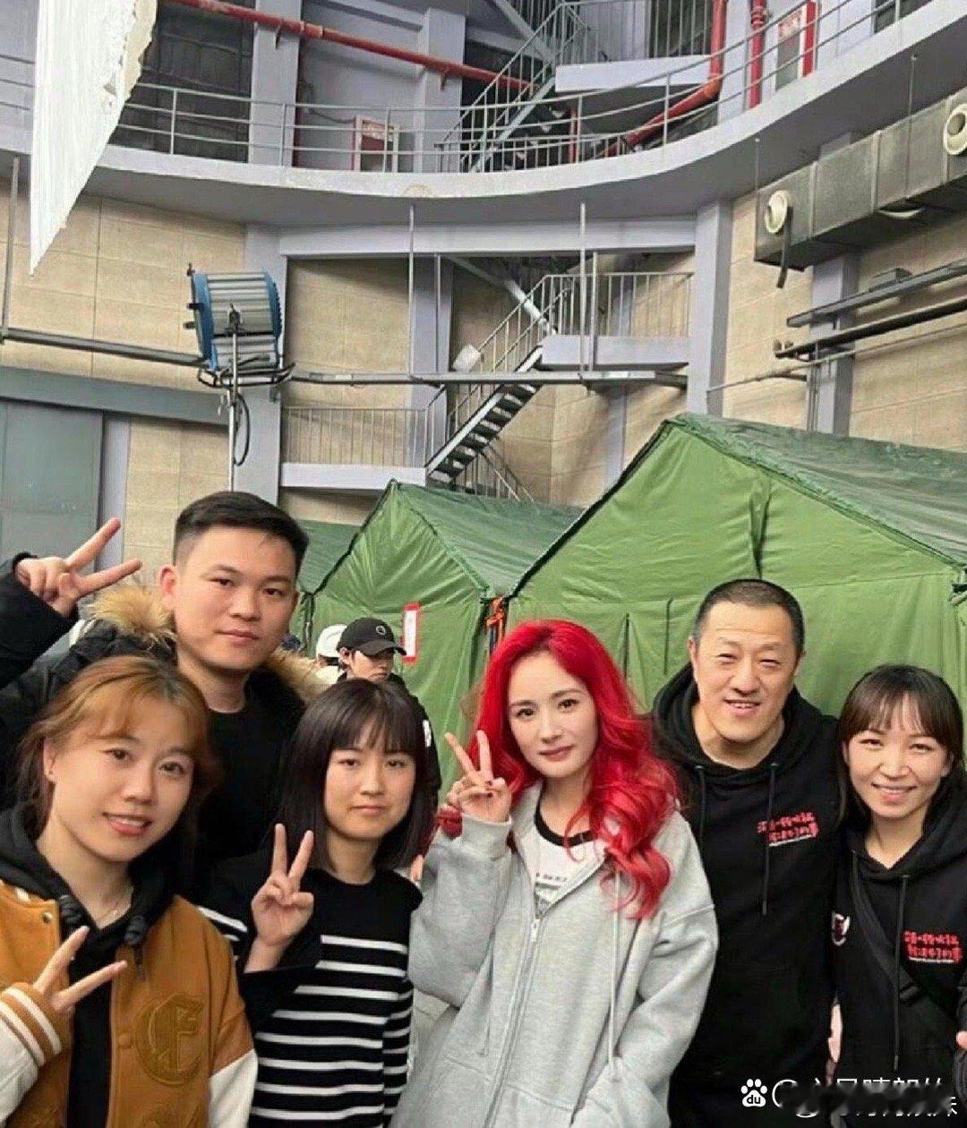 红发杨幂在街头的独特造型引发关注，令人眼前一亮。这个鲜明的颜色衬托出她不同以往的