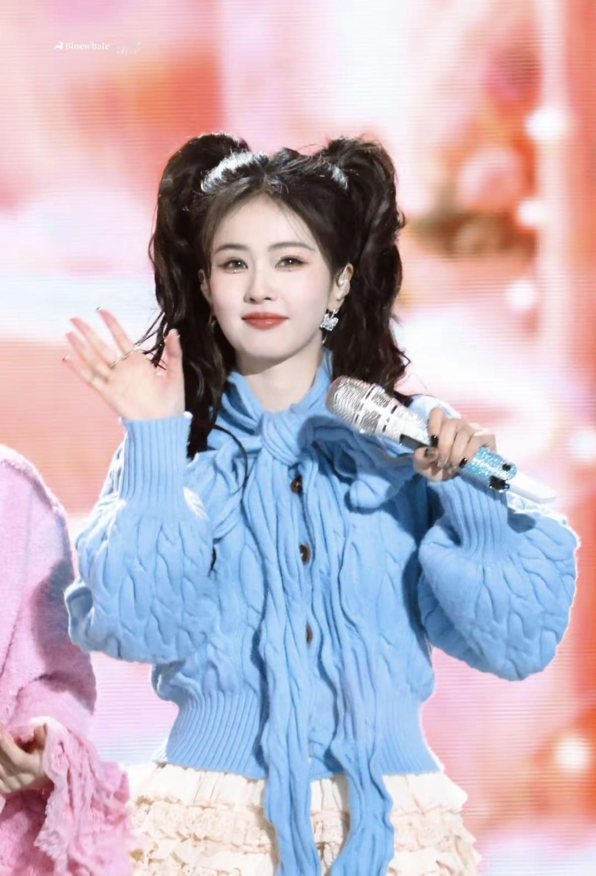 蓝色针织开衫的绑带设计为视觉焦点，弱化了针织单品的厚重感，双马尾造型则强化了灵动